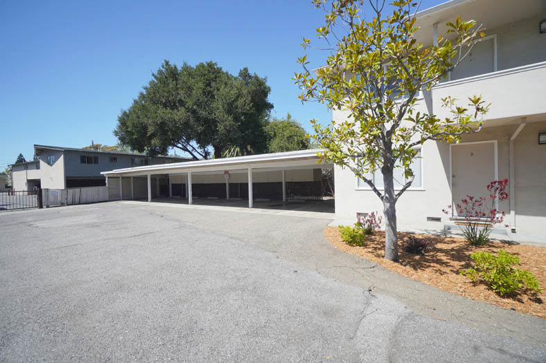 an empty parking lot in front of a white building
